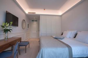 a bedroom with a bed and a desk and a television at Hotel Majestic in Budva