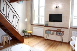 a living room with a staircase and a flat screen tv at Le Grand-Victoire, Centre-Ville - Parking Gratuit in Bordeaux