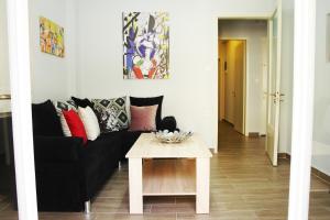 a living room with a black couch and a table at Marlera Corfu Old Town Apt in Corfu Town