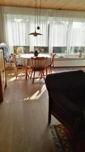 a living room with a table and chairs and windows at Haus Antje in Norddeich