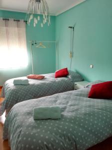 2 camas en un dormitorio con paredes azules en Apartamento Cantalejo, en Cantalejo