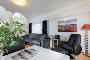 a living room with two chairs and a table at The Queen Luxury Apartments - Villa Carlotta in Luxembourg