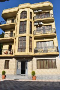 un edificio giallo alto con balconi sopra di Guest house BAGRATIONI a Kobuleti