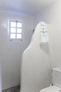 a white bathroom with a toilet and a window at Villa Ippocampi - Adults Only in Koutouloufari
