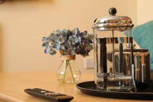 a coffee maker and a remote control on a table at Seashells in Newquay +24 photos