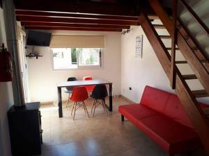 sala de estar con sofá rojo y mesa en Kawsay Complejo de Cabañas en San Antonio de Arredondo