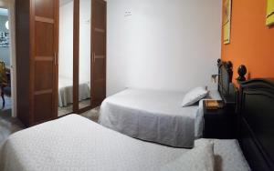 コルドバにあるDS Asturias - Puente Romanoのベッド2台と鏡が備わるホテルルームです。