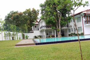 a building with a swimming pool in a yard at Serenity Tissa in Tissamaharama