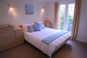a bedroom with a bed and a dresser and a window at Seashells in Newquay