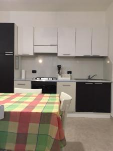 a kitchen with white cabinets and a colorful table at A Villafontana in Bovolone