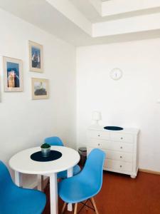 a room with a white table and blue chairs at Hostel Marina in Gdynia