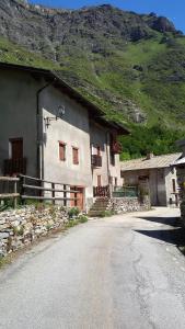 a building on the side of a road next to a mountain at Baita nonno Guido in Moncenisio