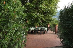 een patio met een tafel, stoelen en bomen bij Villa Coli in Calci