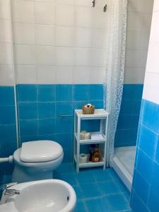 niebiesko-biała łazienka z toaletą i umywalką w obiekcie Residence La Perla w mieście Stalettì