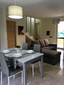 salon ze stołem i kanapą w obiekcie Residence La Perla w mieście Stalettì