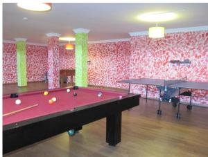 a room with a pool table and two ping pong tables at Villa Tiago in Loulé