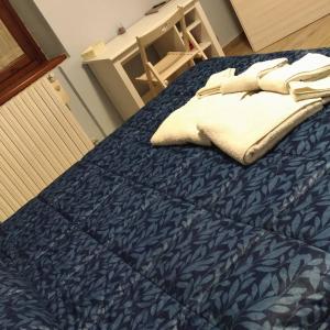 Bett mit blauer Decke und weißer Bettwäsche in der Unterkunft La rosa dei venti in Legnano