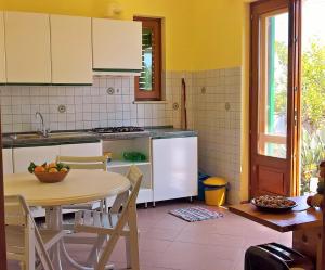 a kitchen with a table and a table and chairs at Seafront Apartments Garden House in Taormina