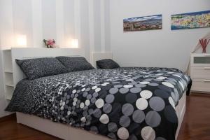 een slaapkamer met een bed met een zwart-wit dekbed bij Sole e Luna in Pompei