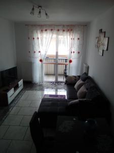 a living room with a couch in front of a window at Sloneczny apartament w Giżycku in Giżycko