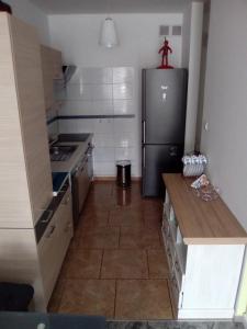 een keuken met een roestvrijstalen koelkast en tegelvloeren bij Sloneczny apartament w Giżycku in Giżycko