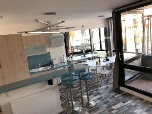 a kitchen with a sink and a counter with stools at MARINA 177 DEAUVILLE in Deauville