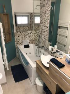 a bathroom with a tub and a toilet and a sink at MARINA 177 DEAUVILLE in Deauville