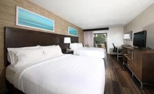 ein Hotelzimmer mit einem großen Bett und einem TV in der Unterkunft Holiday Inn Hotel Peterborough Waterfront, an IHG Hotel in Peterborough