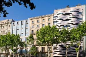 budynek z drzewami przed nim w obiekcie Suites Avenue w Barcelonie