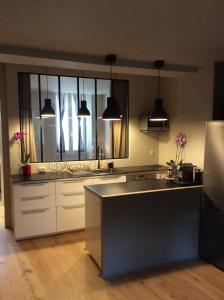 uma cozinha com armários brancos e uma grande janela em T2 centre ville avec extérieur em Avignon