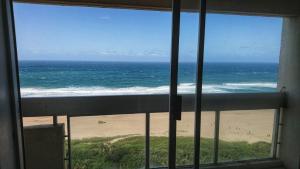 a view of the ocean from a window of a beach at Stella Maris in Amanzimtoti