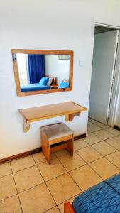 Habitación con espejo, banco y espejo. en Stella Maris, en Amanzimtoti