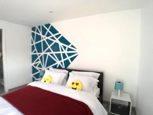 1 dormitorio con 1 cama con 2 almohadas en La Suite Emoji - SDP, en Lagny