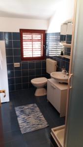 a blue tiled bathroom with a toilet and a sink at Begovi Dvori in Rab +18 photos