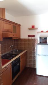 a kitchen with wooden cabinets and a stove top oven at Begovi Dvori in Rab
