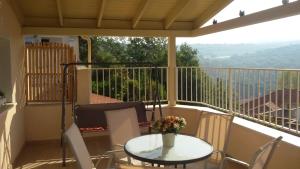 a balcony with a table with a vase of flowers on it at A Place To Remember in Ma‘alot