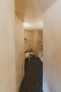 a room with a toilet, sink, and stairway at Hotel Sassi in Matera