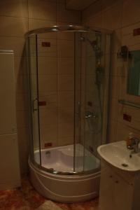 a shower with a glass door next to a sink at Happy Day in Narva