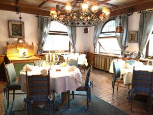 a dining room with tables and chairs and a chandelier at Landhotel Traube in Baden-Baden