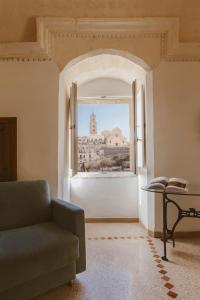 a living room filled with furniture and a large window at Hotel Sassi in Matera