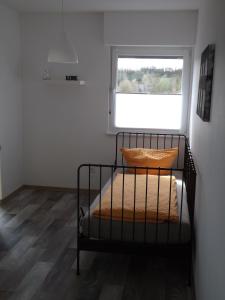 a small bedroom with a bed with a window at Alexander´s Ferienwohnungen in Gerlingen