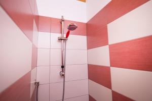 a shower in a bathroom with red and white tiles at Casa Daniela in Noto +12 photos