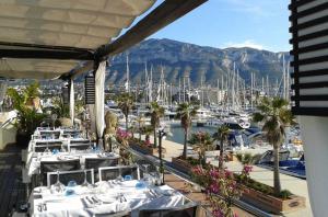 a view of a marina with white tables and boats at Pl Les Bovetes Apt in Denia