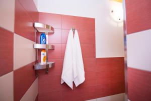 ノートにあるCasa Danielaの赤い壁に白いタオルを敷いたバスルーム