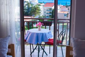 a table with a vase of flowers on a balcony at Villa Šutić in Promajna