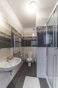 a white bathroom with a sink and a toilet at Willa Magda in Jastrzębia Góra