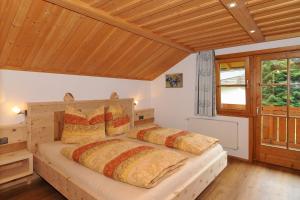 1 dormitorio con 2 camas en una habitación con techos de madera en Haus am Kienberg, en Schwangau