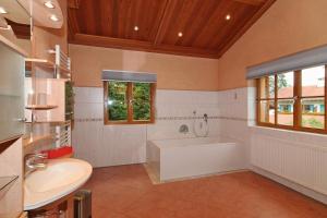 baño grande con bañera y lavamanos en Haus am Kienberg, en Schwangau