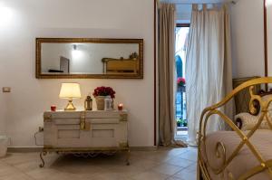 ナポリにあるdomus sanfeliceのベッドルーム(鏡付)1室、ドレッサー(ランプ付)