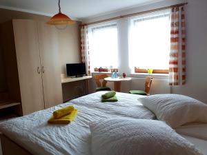 a bedroom with a bed with two yellow towels on it at Landhaus Levitzow in Levitzow